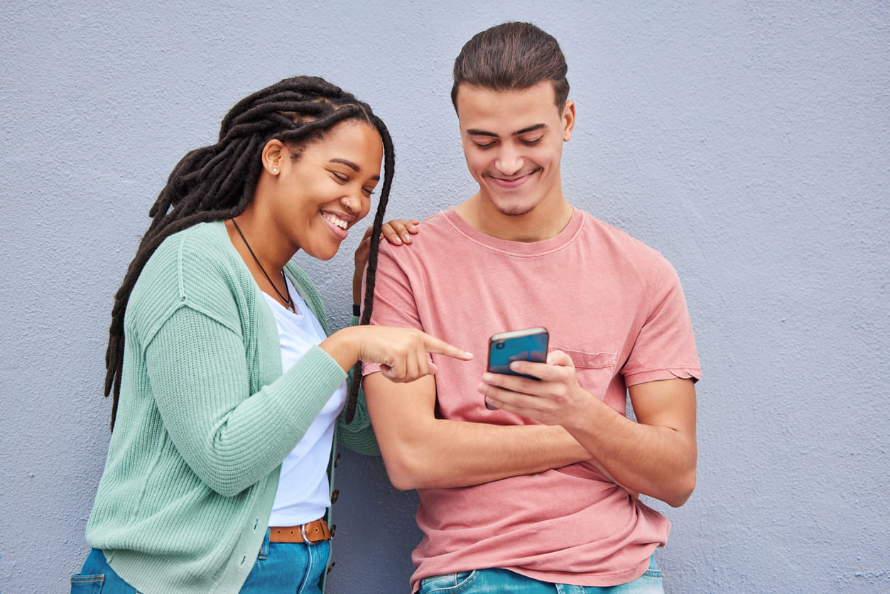 mulher e homem olhando para um celular, onde está sendo veiculado parcerias no instagram